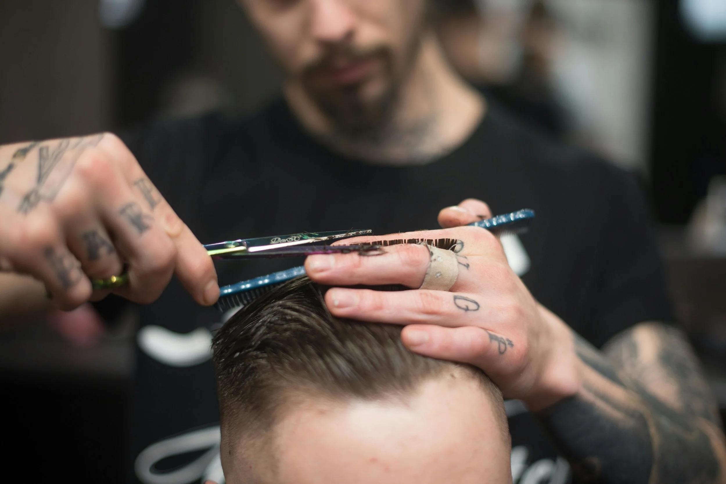 Barber giving a precision scissor cut at Onyx Barber Co.